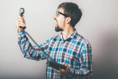 Telefon ofisinde bağıran sakallı bir adam.