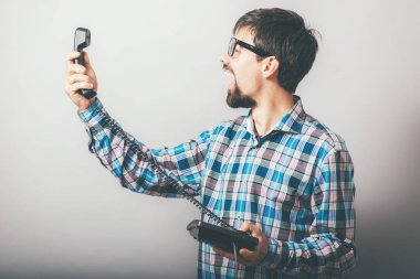 Telefon ofisinde bağıran sakallı bir adam.