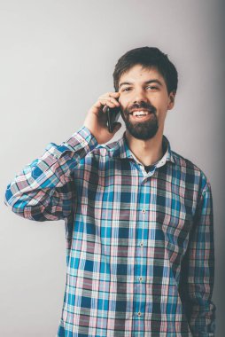 Sakallı adam telefonda konuşuyor.