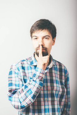 Adam parmağını dudaklarına koydu.