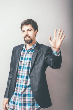 Adam gri arkaplanda merhaba diyor.