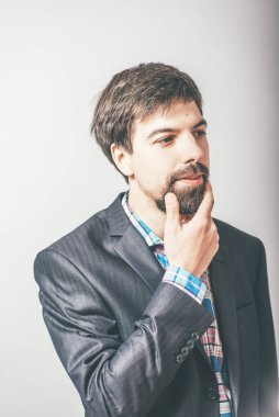Gri arkaplanı düşünen sakallı iş adamı