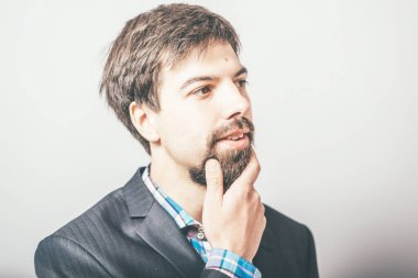 Gri arkaplanı düşünen sakallı iş adamı