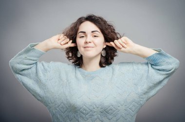 Hiçbir şey duymak istemiyorum. Elleriyle kulaklarını kapatan genç bir kadın. 