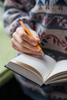 Kağıda kalem yazan insan elleri.