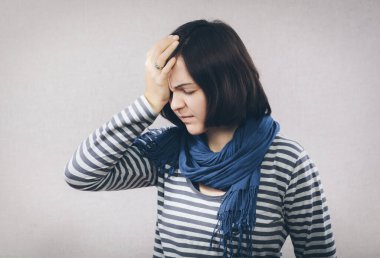 Yuong kadını beyaz arka planda acı içinde başını tutuyor.