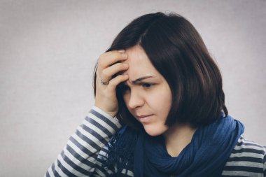 Depresyondaki genç kız başını tutuyor.