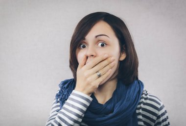 Elleri açık, ağzı açık ve kocaman gözleri olan şaşırmış bir kadın.