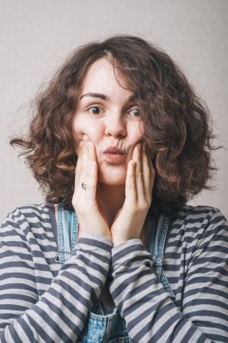 Genç bir kadın yakından öpüyor.