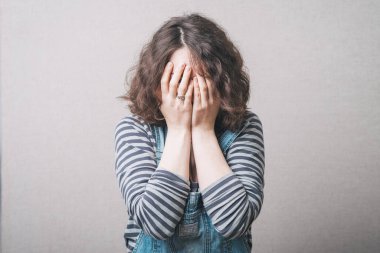 Kız üzgün ve elleriyle yüzünü örtüyor. Tulum giymiş dikiz aynasıyla.