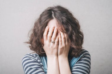 Kız üzgün ve elleriyle yüzünü örtüyor. Tulum giymiş dikiz aynasıyla.