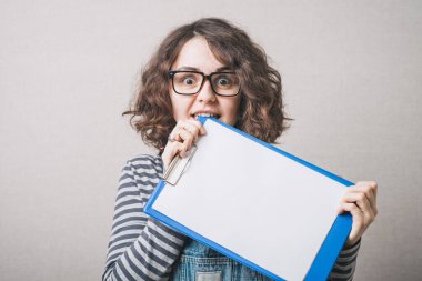 Girl with glasses biting teeth in the book cover clipart