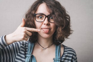 Kız dilinde parmağını gösteriyor.