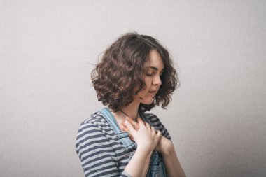 Kadın elleri göğsünde. Gri arkaplan.