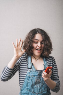 Kadın telefonda iyi bir SMS mesajı okuyor. Gri arkaplan