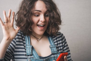 Kadın telefonda iyi bir SMS mesajı okuyor. Gri arkaplan