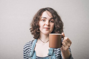 Bir kadın kahve ya da çay ikram eder. Gri arkaplan