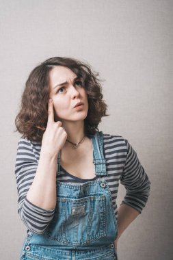 Parmağını şakağına dayayan bir kız.