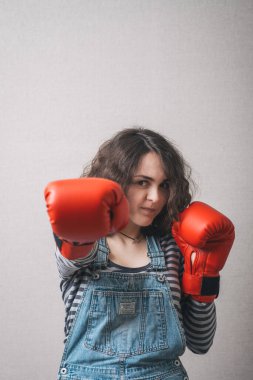 Komik kadın, boks eldivenli, tulum giymiş.