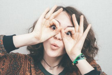 Kız sataşıyor, dil gösteriyor, dürbün gibi elleri var.