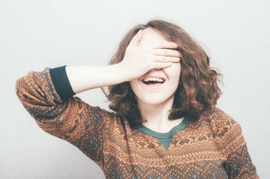 Kız elleriyle gözlerini kapatıyor.