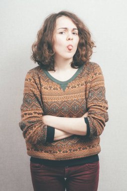 Kız, stüdyo arka planında dil gösteriyor