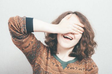 Kız elleriyle gözlerini kapatıyor.