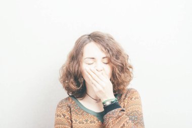 Stüdyo arka planında esneyen genç bir kadın.