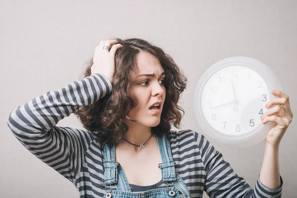 Una Mujer Mira Reloj Grande Sosteniendo Cabeza Retrasa Fondo Gris — Foto de Stock
