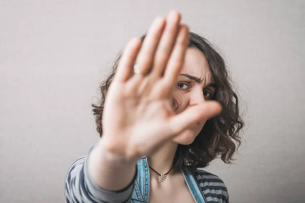 Eine Frau Zeigt Eine Geste Auf Grauem Hintergrund — Stockfoto
