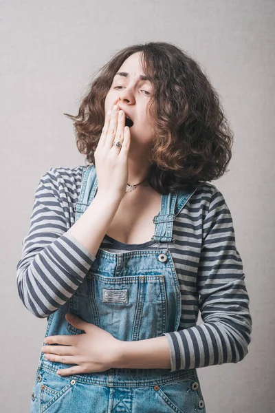 Mujer Bosteza Sobre Fondo Gris —  Fotos de Stock