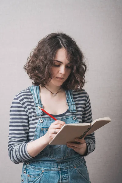 Frau Schreibt Ein Notizbuch Gekleidet Overalls — Stockfoto