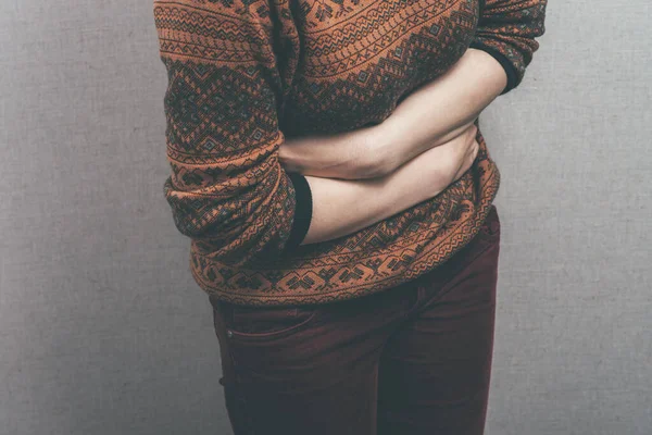 スタジオを背景にした女性の胃の痛み — ストック写真