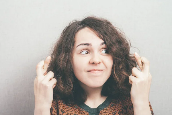 Vrouw Vingers Gekruist Tegen Studio Achtergrond — Stockfoto