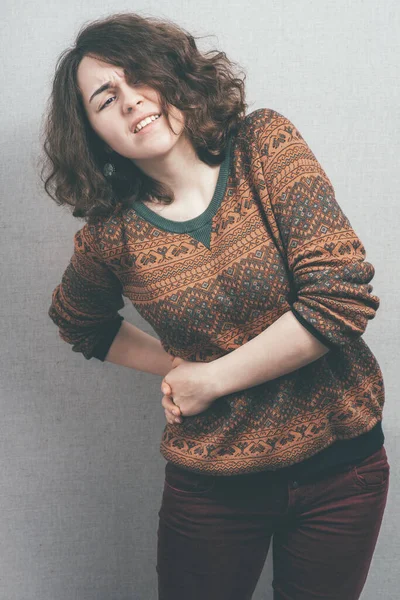 woman, side ache against studio background