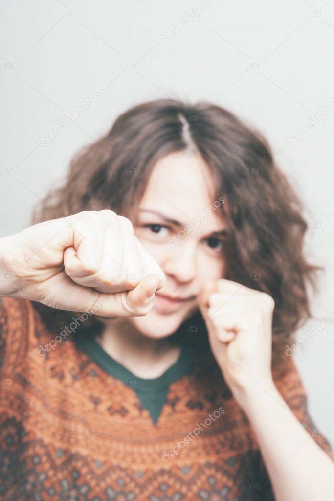 Girl with fists against studio background