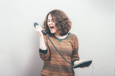 Kadın ev telefonunda bağırıyor.