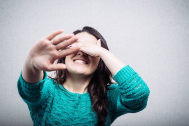 Yüzünü kapatan genç bir kadın.