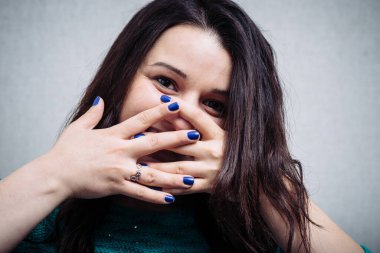 Elleri ağzında gülümseyen bir kız