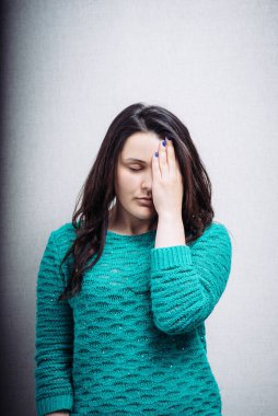Güzel bir kadın bir gözünü kapatır ve başı ağrır.