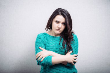 Gri arka planda üzgün bir kız