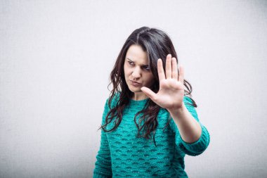 Gri arka planda durduğunu gösteren kızlar