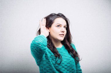 Kız gri arka planda kulak misafiri oluyor.