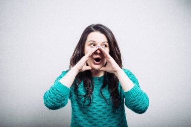 Gri arka planda birini arayan bir kız