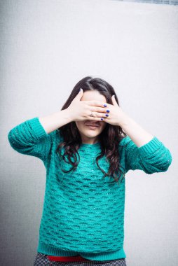 Kız elleriyle gözlerini kapatıyor.