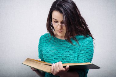 Gözlüklü kız kitap okuyor.