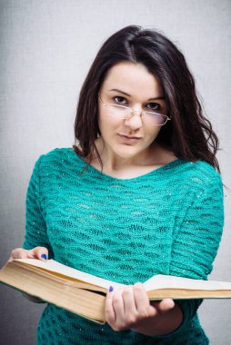 Gözlüklü kız kitap okuyor.