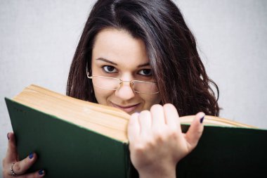 Gözlüklü kız kitap okuyor.