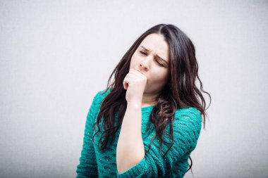 Gri arka planda genç bir kadın