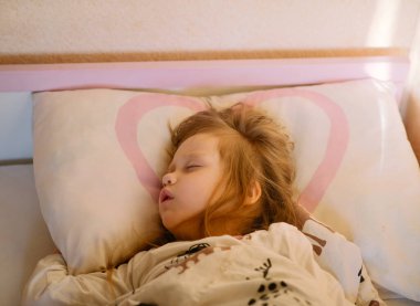 Bebeğim pijamalarıyla yatakta uyuyor.